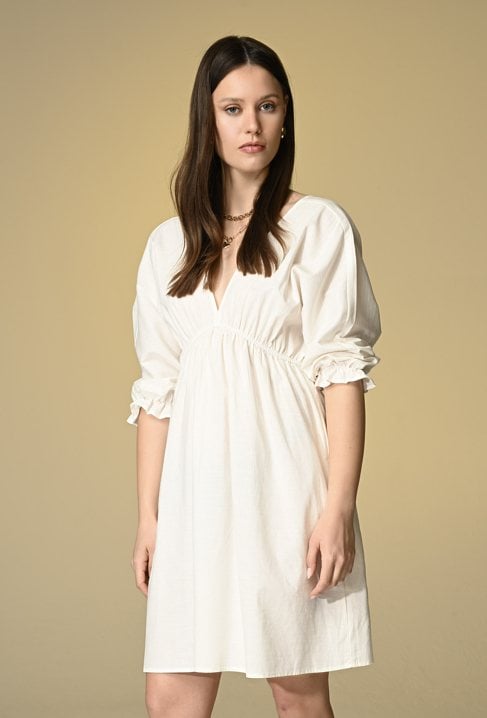 Śmietankowa sukienka z wycięciem na plecach