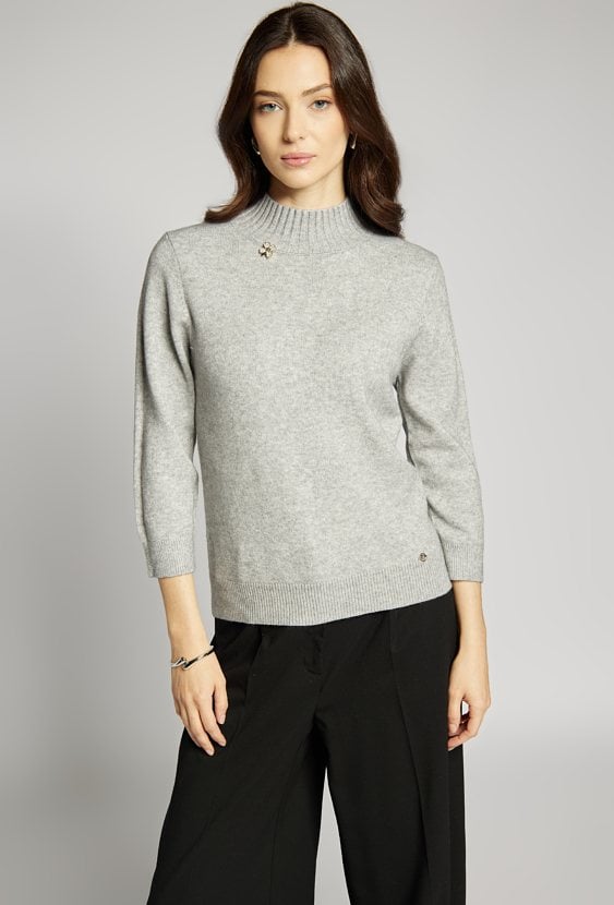 Sweter z ozdobną agrafką