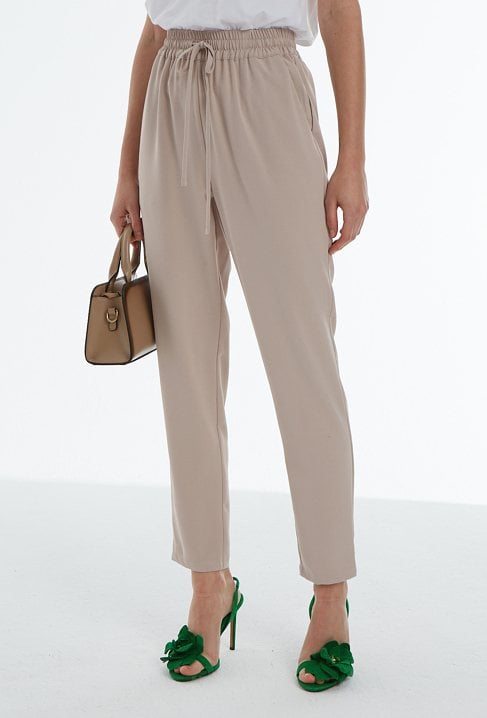 Beżowe spodnie typu chinosy